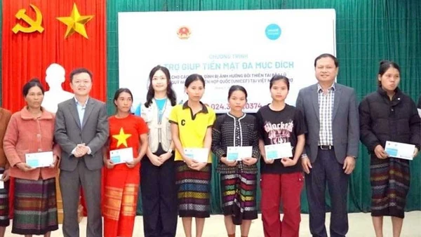 Các đại biểu trao trợ giúp tiền mặt tặng hộ gia đình bị ảnh hưởng thiên tai ở xã Kim Ngân, tỉnh Quảng Trị. (Ảnh NH)