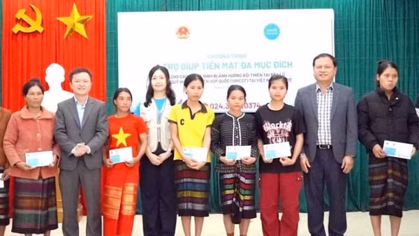 Các đại biểu trao trợ giúp tiền mặt tặng hộ gia đình bị ảnh hưởng thiên tai ở xã Kim Ngân, tỉnh Quảng Trị. (Ảnh NH)