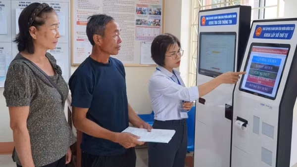 Cán bộ phường Mường Thanh hướng dẫn người dân thực hiện thủ tục hành chính trên cây ki-ốt tại trụ sở Ủy ban nhân dân phường.