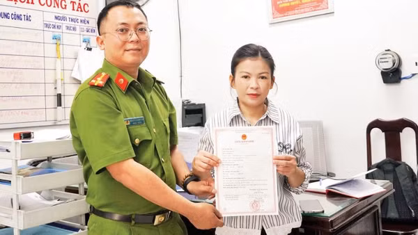 Thượng úy Nguyễn Quang Đạt trao giấy khai sinh cho chị Nguyễn Thị Trúc Mai.