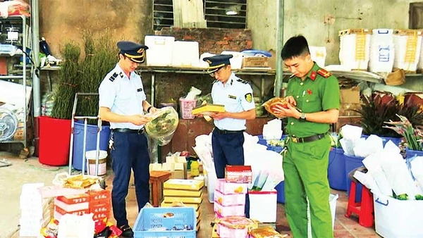 Lực lượng chức năng phát hiện, thu giữ bánh trung thu và một số thực phẩm nhập lậu tại hộ kinh doanh Lý Nguyễn Minh Châu. (Ảnh TRÍ DŨNG)