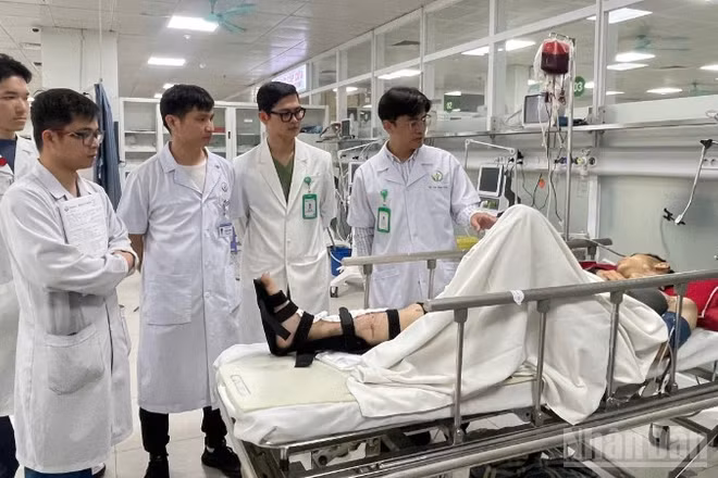 Tiến sĩ, bác sĩ Cao Mạnh Thấu, Phó Trưởng khoa Phẫu thuật và Ung bướu, Bệnh viện Hữu nghị Việt Đức (phải) cùng tour trực hội chẩn trường hợp bệnh nhân chấn thương do tai nạn giao thông. 