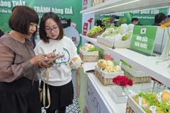Chuyên viên của Cục Quản lý và Phát triển thị trường trong nước hướng dẫn khách tham quan nhận diện sản phẩm quả lê Hàn Quốc.