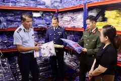 Lực lượng chức năng kiểm tra tại cơ sở kinh doanh quần áo thể thao trên phố Hoàng Công Chất, phường Phú Diễn, Hà Nội.