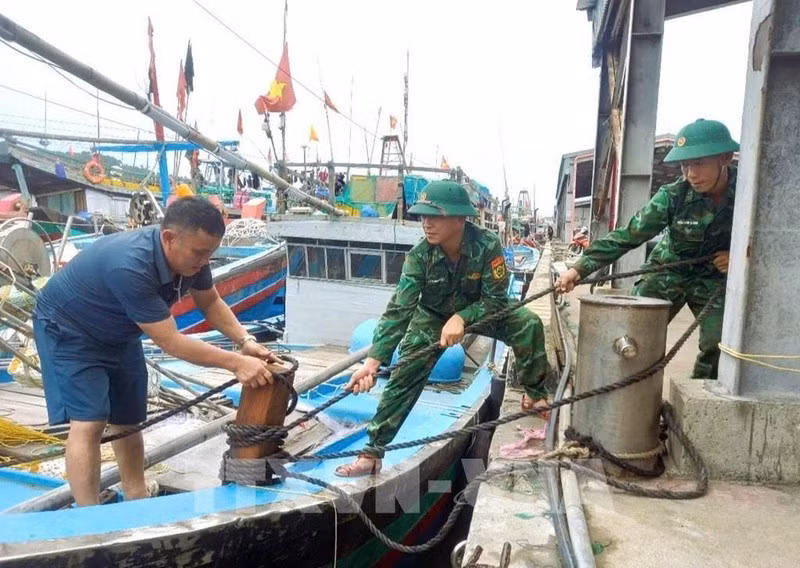 Bộ đội biên phòng tỉnh Nghệ An giúp ngư dân gia cố tàu ứng phó bão số 3. Ảnh: TTXVN
