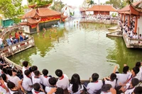 Các em học sinh xem trình diễn rối nước ở làng Thư Lâm, thành phố Hà Nội. (Ảnh: Báo Nhân Dân)