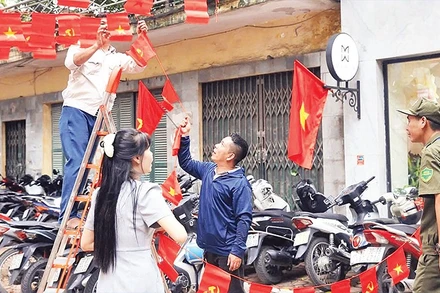 Người dân Hà Nội trang trí cờ hoa mừng Quốc khánh. (Ảnh NGUYỄN VŨ)