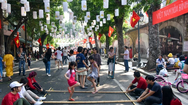 Người dân và du khách trải nghiệm các hoạt động văn hoá tại phố bích hoạ Phùng Hưng. (Ảnh: ĐĂNG ANH)