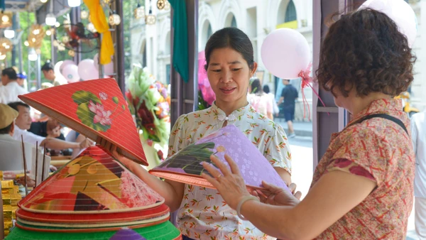 Du khách thích thú với những chiếc nón lá tại không gian làng nghề nón làng Chuông (huyện Thanh Oai, Hà Nội) trong khuôn khổ Festival Thu Hà Nội lần thứ 2 năm 2024. (Ảnh: THẾ ĐẠI)