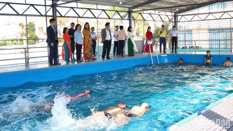 Các em học sinh bơi lội tại bể bơi mới.
