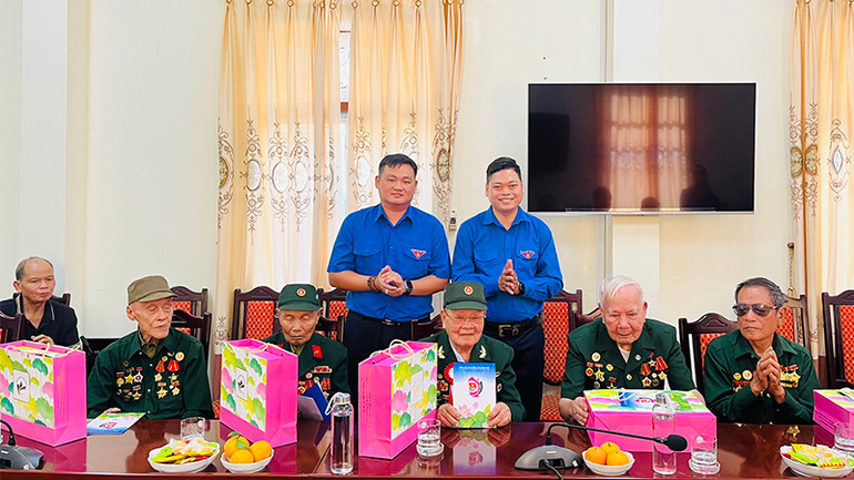 Phó Bí thư Tỉnh đoàn Đồng Tháp Lê Hoàng Quyết (bên phải) trao tặng quà cho các cựu quân nhân tỉnh Điện Biên.