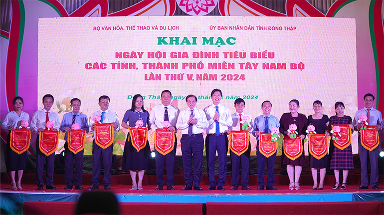 Đại diện 13 tỉnh, thành phố miền Tây Nam Bộ nhận cờ lưu niệm của ban tổ chức và Bé Sen - Biểu tượng quảng bá hình ảnh của tỉnh Đồng Tháp. (Ảnh: HỮU NGHĨA)