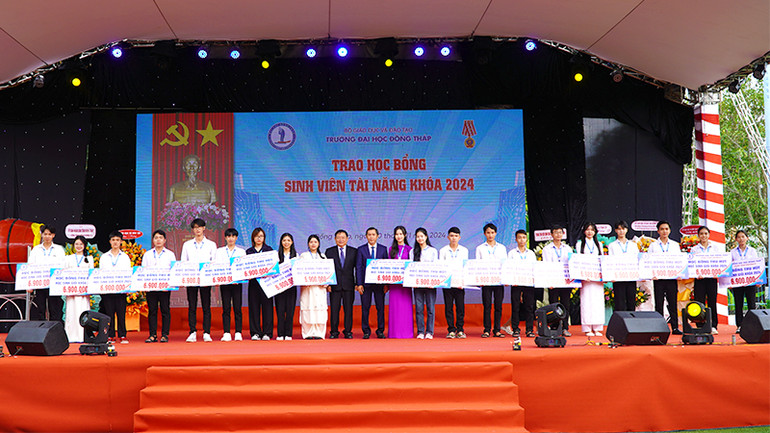 Lãnh đạo Trường đại học Đồng Tháp trao học bổng khuyến học cho các sinh viên. (Ảnh: HỮU NGHĨA)