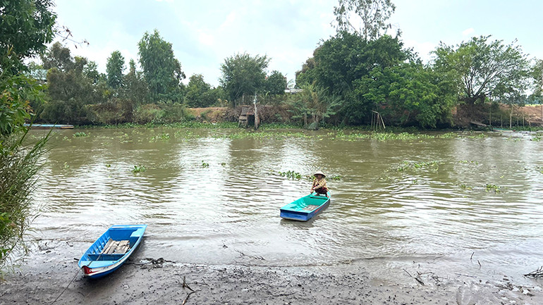 Không có đường, người dân phải bơi xuồng qua sông.