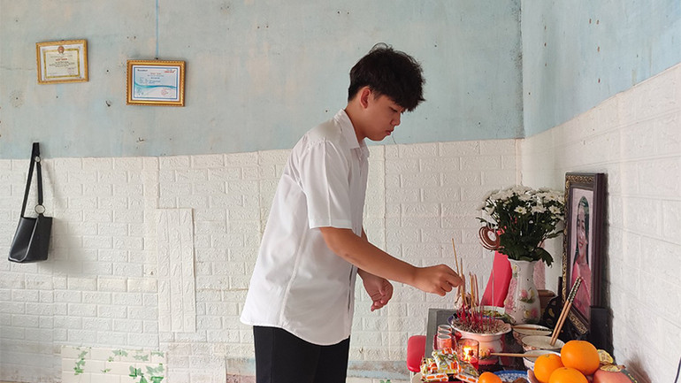 Em Hồ Minh Khang thắp hương viếng mẹ.