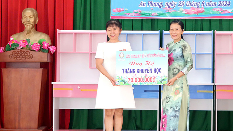 Đại diện lãnh đạo Công ty trách nhiệm hữu hạn một thành viên Xổ số kiến thiết Đồng Tháp (bên trái) trao bảng tượng trưng ủng hộ nguồn lực cho xã An Phong.