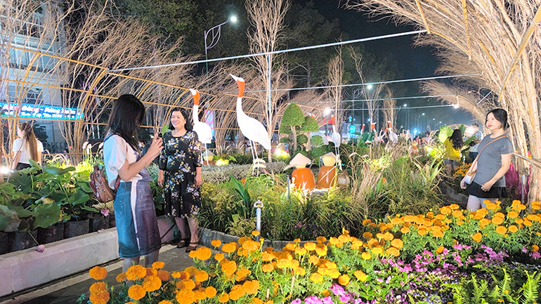 Du khách tham quan, chụp ảnh tại một đại cảnh của đường hoa. Ảnh: HỮU NGHĨA