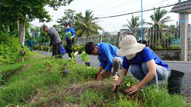 Trồng hoa trên tuyến đường nông thôn mới kiểu mẫu tại ấp 3, xã Đốc Binh Kiều. (Ảnh: HOÀNG KHA)