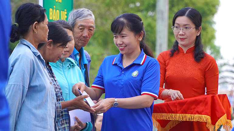 Giám đốc Công ty TNHH MTV Xổ số kiến thiết Đồng Tháp Đặng Thị Ngọc Hiền trao quà Tết cho người bán vé số lẻ. (Ảnh: HỮU NGHĨA)