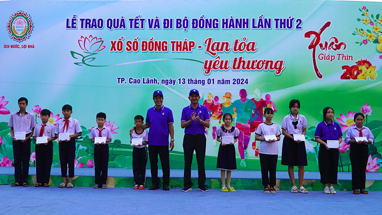 Bí thư Đảng ủy khối các cơ quan tỉnh Đồng Tháp Nguyễn Ngọc Thương và Chủ tịch Công ty TNHH MTV Xổ số kiến thiết Đồng Tháp Lưu Hoàng Tân trao quà Tết cho trẻ em mồ côi. (Ảnh: HỮU NGHĨA)