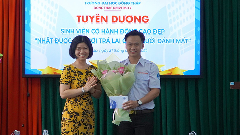 Lãnh đạo Khoa Giáo dục tiểu học - mầm non tặng hoa và tiền thưởng cho sinh viên Nguyễn Minh Toàn. (Ảnh: HỮU NGHĨA)