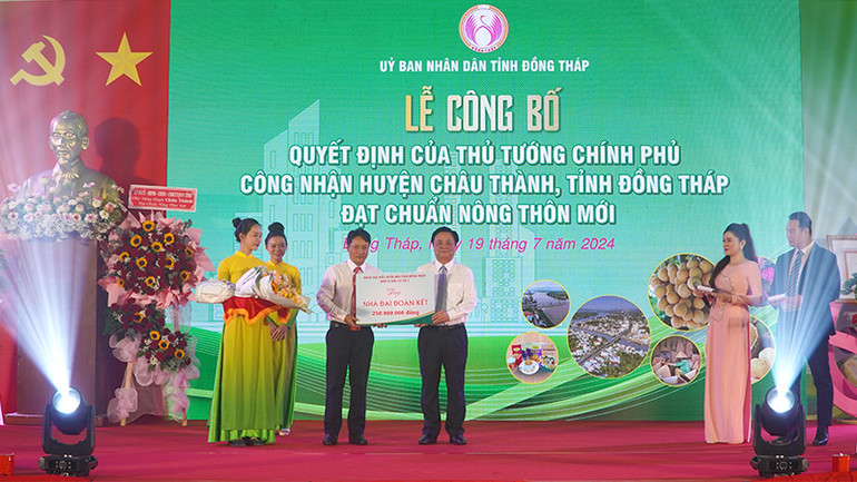 Bộ trưởng Lê Minh Hoan thay mặt Đoàn đại biểu Quốc hội đơn vị tỉnh Đồng Tháp, đơn vị bầu cử số 3, trao bảng tượng trưng tặng 5 căn nhà Đại đoàn kết. (Ảnh: HỮU NGHĨA)