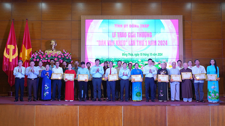 Lãnh đạo tỉnh Đồng Tháp trao giải và chụp ảnh lưu niệm cùng đại diện 20 tập thể, cá nhân nhận Giải thưởng “Dân vận khéo”. (Ảnh: HỮU NGHĨA)