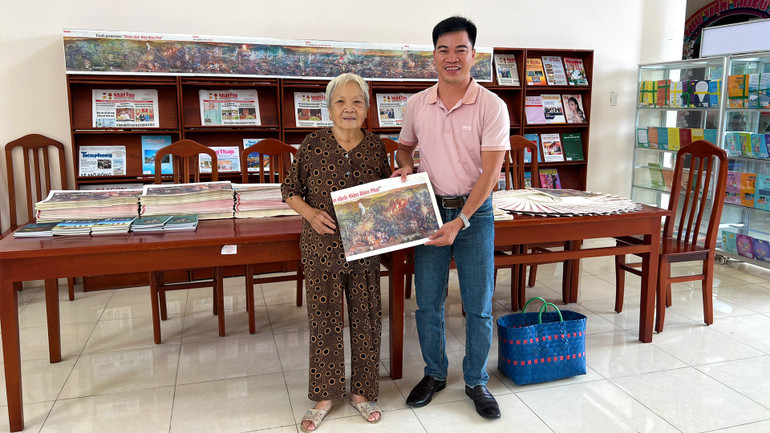 Bác Phạm Kim Thanh tại buổi nhận tranh. Lúc này, bác đang xách giỏ đi chợ.