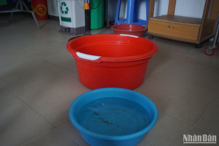 Nhân viên y tế hứng thau, xô để nước không tràn ra hành lang.
