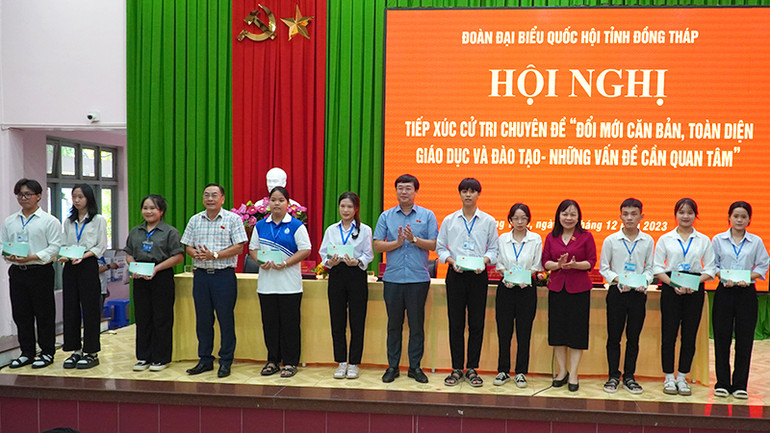 Đại biểu Quốc hội trao học bổng cho sinh viên. (Ảnh: HỮU NGHĨA)