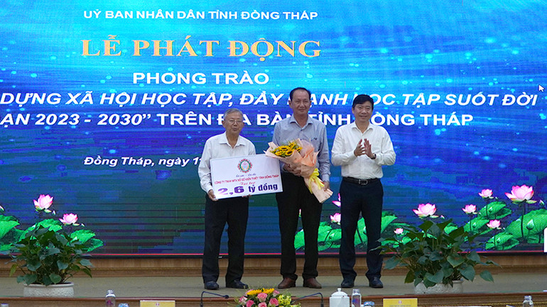 Lãnh đạo Công ty Trách nhiệm hữu hạn Một thành viên Xổ số Kiến thiết Đồng Tháp trao bảng tượng trưng ủng hộ Quỹ Khuyến học Nguyễn Sinh Sắc.