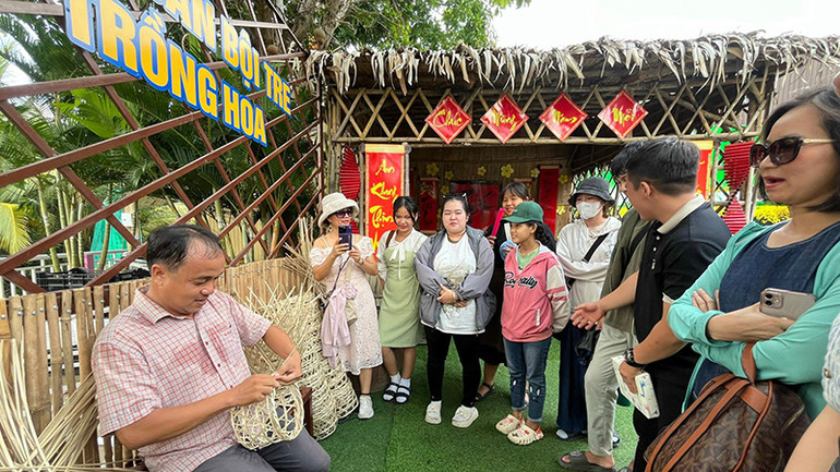 Nông dân làng hoa biểu diễn nghề đan bội tre trồng hoa.