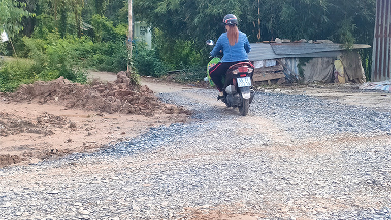 Đoạn đường đất dài gần 5m đã được cán đá mi để người dân thuận tiện đi lại. (Ảnh: HỮU NGHĨA)