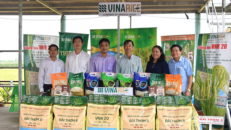 Lãnh đạo tỉnh Đồng Tháp và huyện Tháp Mười tham quan, chụp ảnh lưu niệm cùng các doanh nghiệp tại một buổi trưng bày, giới thiệu mặt hàng lúa gạo ở xã Mỹ Đông, huyện Tháp Mười. (Ảnh: HỮU NGHĨA)