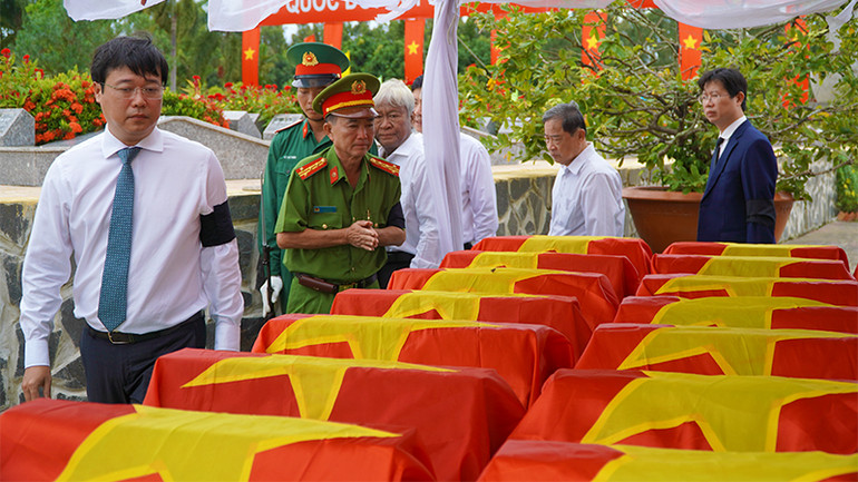 Đoàn đại biểu viếng hài cốt liệt sĩ. (Ảnh: HỮU NGHĨA)