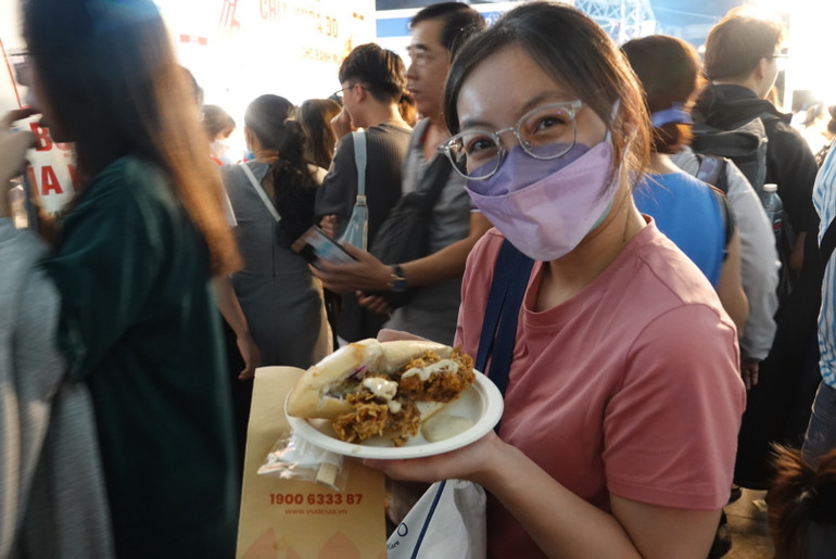 Một bạn trẻ vui mừng khi mua được ổ bánh mì cua.