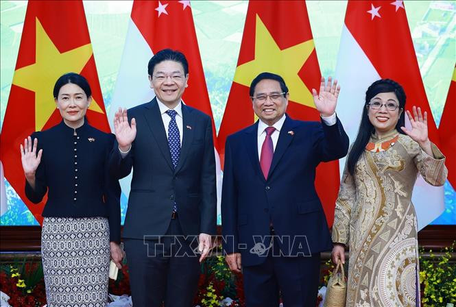 Thủ tướng Phạm Minh Chính và Phu nhân cùng Thủ tướng Singapore Lawrence Wong và Phu nhân chụp ảnh chung. (Ảnh: Dương Giang/TTXVN)