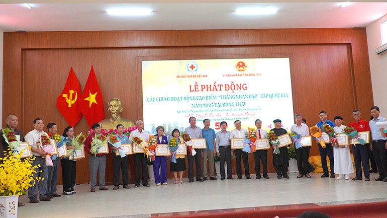 Tặng hoa cảm ơn các đơn vị đã đóng góp nguồn lực thực hiện công trình, phần việc nhân đạo ở địa phương. (Ảnh: HỮU NGHĨA)