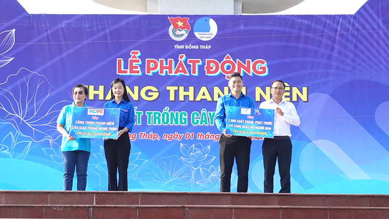 Trao bảng tượng trưng hỗ trợ kinh phí xây dựng cầu giao thông nông thôn; khám, phát thuốc và tặng 2.000 quà cho người dân có hoàn cảnh khó khăn. (Ảnh: NHƯ ANH)