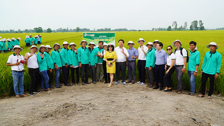 Các đại biểu dự hội nghị thăm quan ruộng mô hình của hộ anh Nguyễn Thanh Xuân, ngụ ấp 4, xã Thạnh Lợi, huyện Tháp Mười. (Ảnh: HỮU NGHĨA)