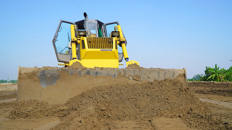 Cán bộ, tài xế tất bật trên công trường trong những ngày Tết. (Ảnh: HỮU NGHĨA)