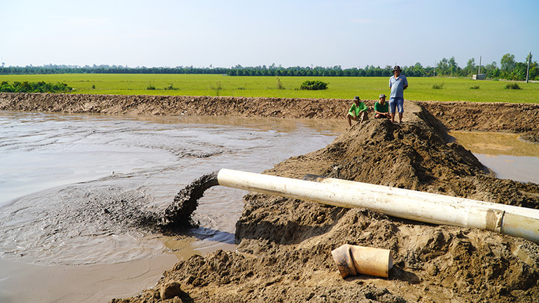Cát đang được bơm vào công trường cao tốc. (Ảnh: HỮU NGHĨA)