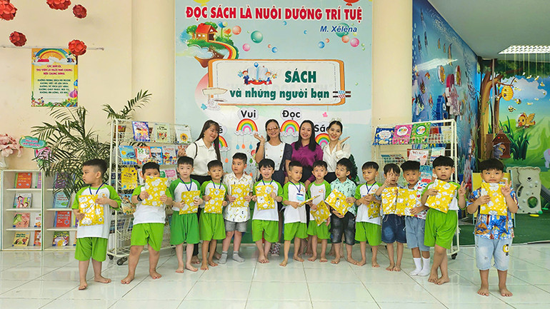 Phó Giám Thư viện tỉnh Đồng Tháp Dương Thị Kim Dung (thứ 2 từ phải qua) trao quà hoạt động tô màu tranh vẽ cho các bé Trường mầm non Sao Mai.