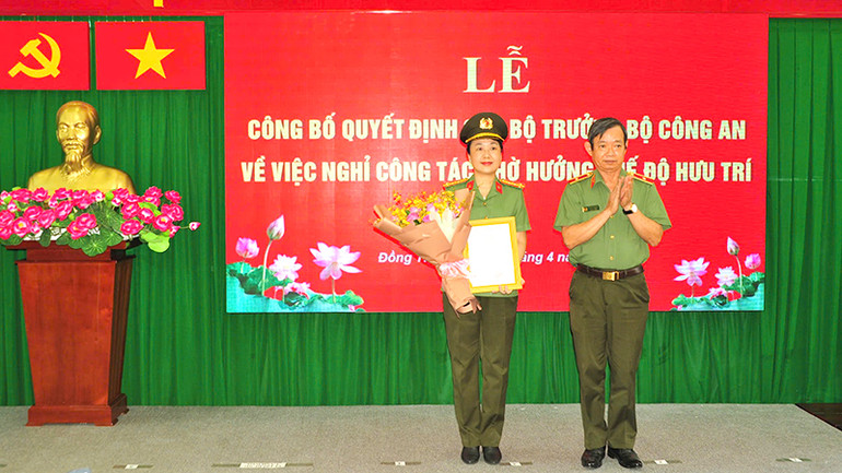 Thiếu tướng Huỳnh Văn Hải, Phó Cục trưởng Cục Tổ chức cán bộ trao quyết định của Bộ trưởng Công an cho Đại tá Võ Thị Hoài Ngọc. (Ảnh: Công an cung cấp)