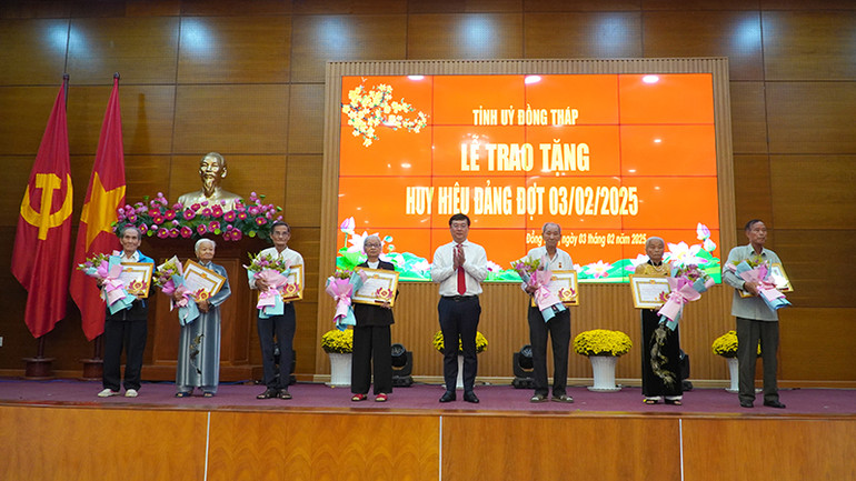 Bí thư Tỉnh ủy Đồng Tháp Lê Quốc Phong trao tặng Huy hiệu 65 năm và 60 năm tuổi Đảng cho 7 đồng chí. (Ảnh: HỮU NGHĨA)