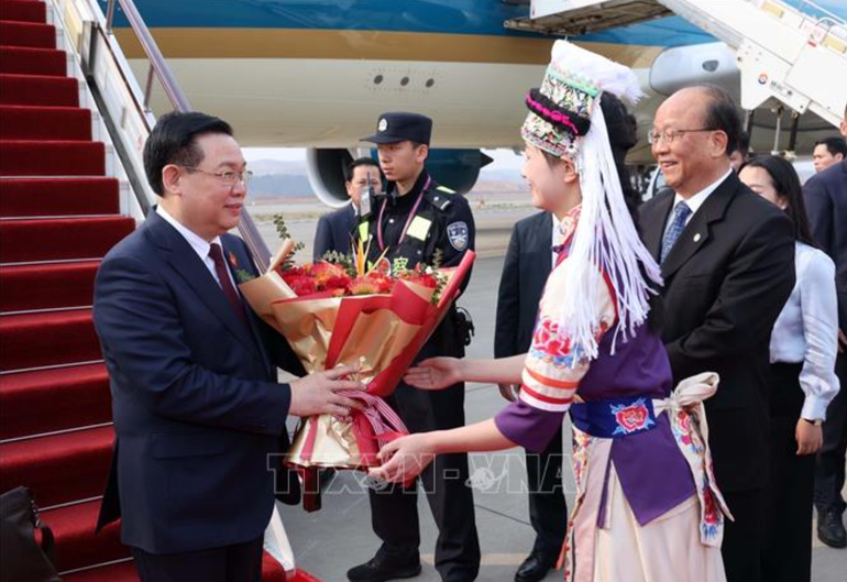 Thiếu nữ tỉnh Vân Nam tặng hoa chào đón Chủ tịch Quốc hội Vương Đình Huệ và Đoàn đại biểu cấp cao Việt Nam tại Sân bay quốc tế Trường Thủy Côn Minh. (Ảnh: TTXVN)