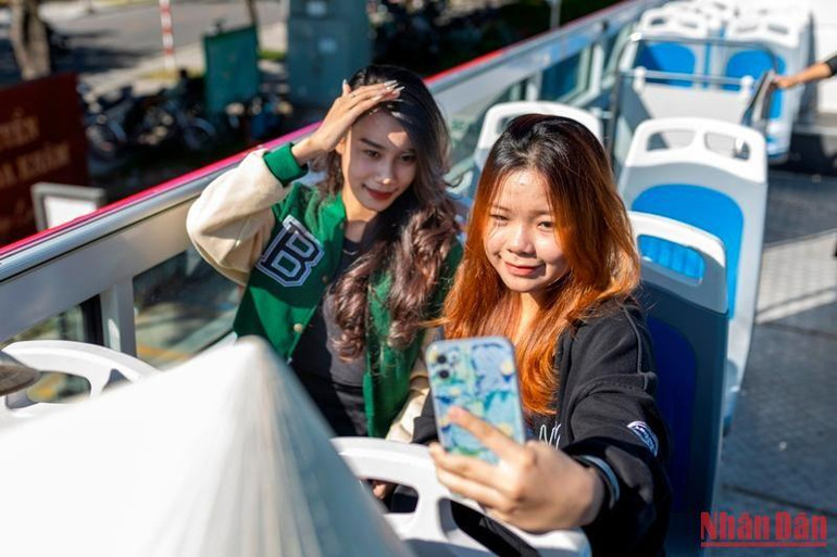 Các bạn trẻ "check in" trên buýt hai tầng thoáng nóc ở Huế.