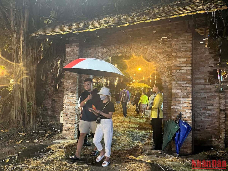 Người dân đội mưa tham dự lễ hội.