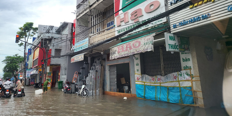 Nước ngập sâu, người dân dùng ván gỗ, bạt ni-lông chắn ngang cửa không cho nước vào nhà.