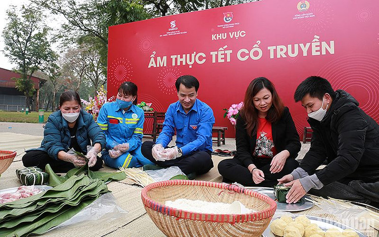 Đại diện Ban Tổ chức và người lao động cùng gói bánh chưng tại khu vực ẩm thực Tết cổ truyền trong khuôn khổ Ngày hội “Cùng nhau làm nên Tết” năm 2023.